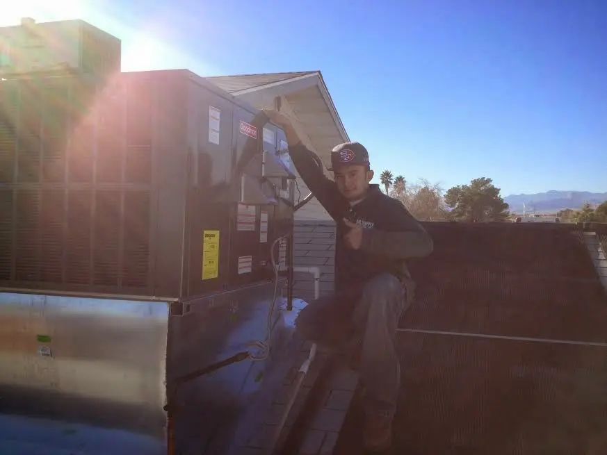 HVAC technician performing AC Tune-Up on a rooftop unit in Price